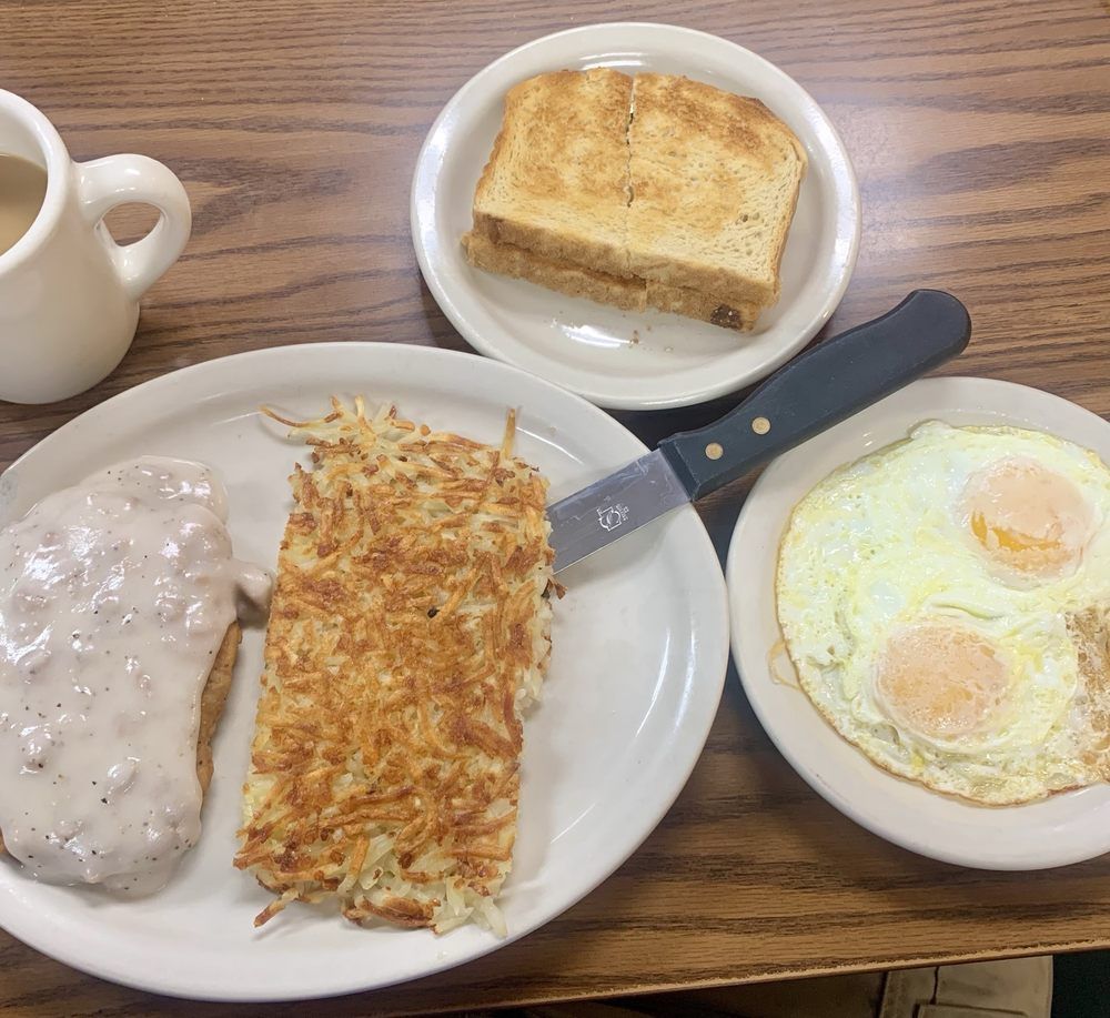 Chicken-fried steak under country gravy with a slab of hash browns, two eggs over easy and toast