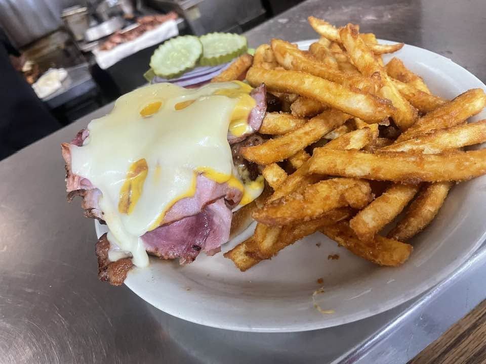 Ham sandwich with melted Swiss and seasoned fries